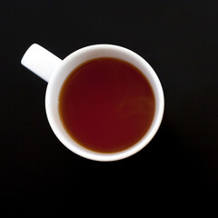 Cup of tea on black table, top view
