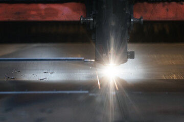 industrial laser cutting system of metal with sparks in production and factory