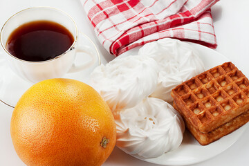 Cup of tea, meringue, grapefruit and waffles