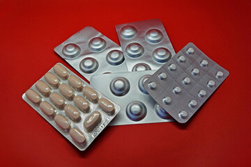 Blister packs of pills on red background