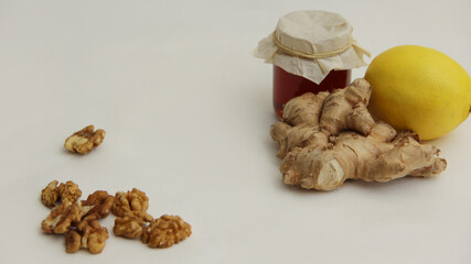 honey, ginger root and lemon, walnuts on a white background