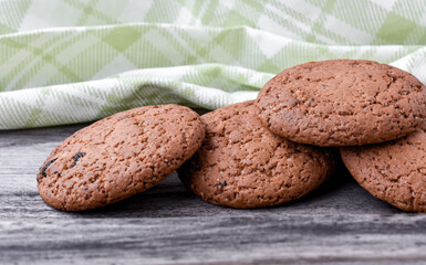 Oatmeal cookies with sugar on an old wooden gray background, kitchen towel. Close-up.