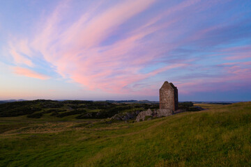 Medieval Tower at sunset with red clouds 
