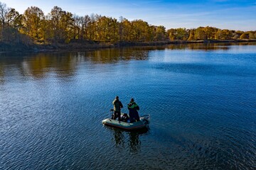 Fishermen in a fishing boat on the lake on a beautiful autumn day.