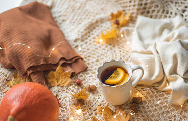 Fototapeta na wymiar Autumn flatlay, Cup of warm tea fall style, fall scene with leaves, lights and acorns, cozy autumn aesthetic concept