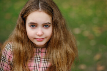 Portrait of a child girl on the background of a green lawn