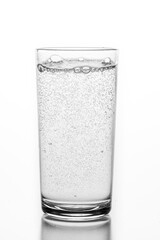 A glass filled with sparkling water. A container for storing liquids.