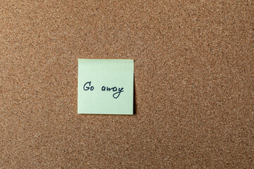 green sticker on brown table. color sticker, motivational, quote, and words, note, message go away