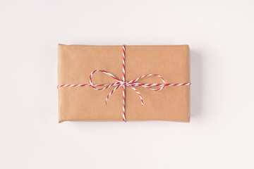 Closeup top above overhead flatlay view photo of one single present box wrapped in eco kraft paper isolated white color background