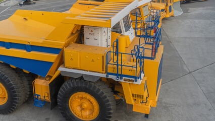 Heavy mining dump trucks are at the factory. Giant mining truck after being from the conveyor is tested at the factory test site. Heavy-duty truck manufacture by the heavy vehicle plant. 