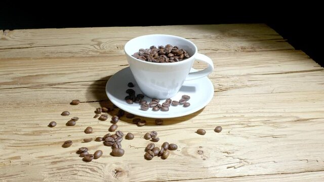 Dolly: Kaffeebohnen in Kaffeetasse auf Holztisch