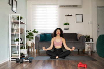 Good-looking female yogi practicing yoga at home