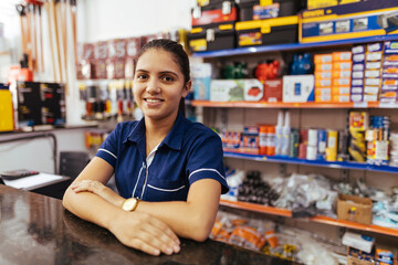 Young latin woman working in hardware store - obrazy, fototapety, plakaty