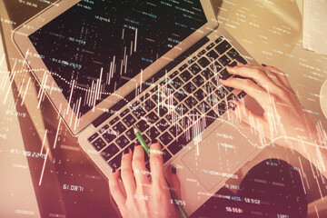 Double exposure of woman hands working on computer and forex chart hologram drawing. Top View....
