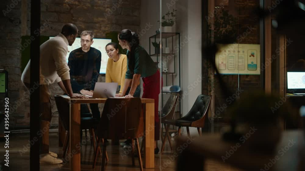 Aufkleber Diverse Multiethnic Team are Having a Conversation in a Meeting Room Behind Glass Walls in a Creative Office. Colleagues Lean On a Conference Table and Discuss Business, App User Interface and Design.
