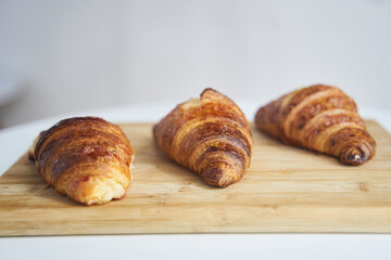 Close up of golden croissants on a wooden tray