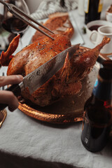 Festive dinner Thanksgiving Day, Christmas dish. Holiday season, celebration with family. Festive table setting. roasted turkey, bread, potato gratin, red wine. Candles, utensils. November, December.