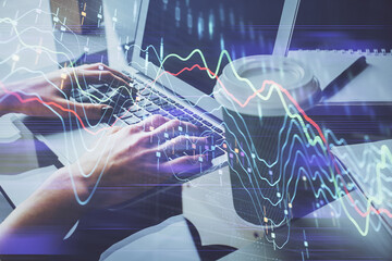 Double exposure of woman hands typing on computer and forex chart hologram drawing. Stock market invest concept.