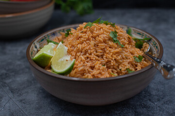Authentic Mexican Spanish rice in ceramic bowl against gray table, copy space