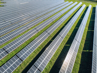 Long Solar panels in a field in a row. View from the drone. Huge Solar panels under the sun. Solar concept