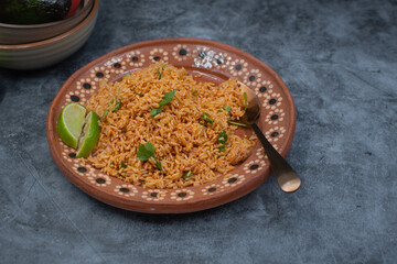 Authentic Mexican rice served in traditional clay plate, copy space