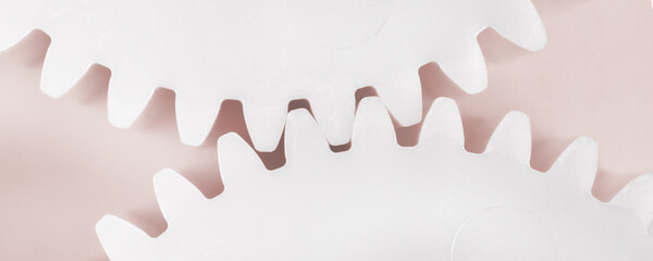 Two meshed gears on beige