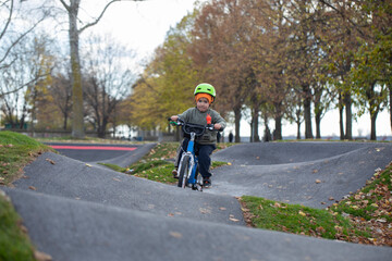 Handsome little boy driving bicycle on a track