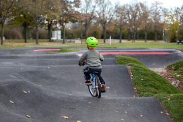Handsome little boy driving bicycle on a track
