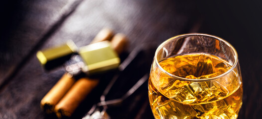 glass with whiskey and ice tongs in the background. Bar or pub image. Relaxation concept, luxurious lifestyle