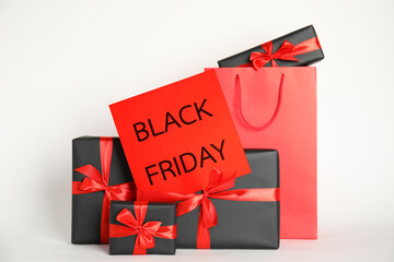 Many gifts and sheet of paper with words Black Friday on white background