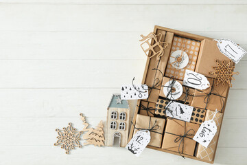 Gift boxes and festive decor on white wooden table, flat lay with space for text. Christmas advent calendar