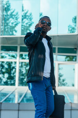 Fototapeta premium Afro American young businessman talking on his mobile phone outside the office building