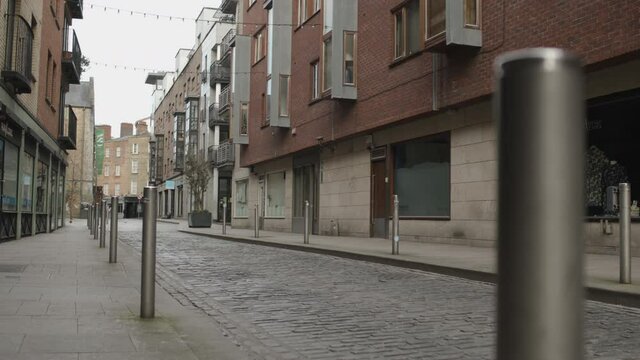 Empty Dublin city street. Distant walkers, birds flying