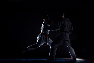 Two judoka fighter man in kimono practicing in the gym