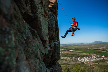Obraz premium Male rock climber hanging over the abyss
