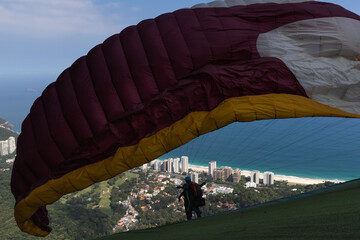 Obraz premium Silhouette of man taking off from paraglider overlooking the sea