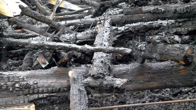 Rain pouring on the burnt woods on the ground with lots of ashes on itin Rakke Laane-Virumaa Estonia in Estonia