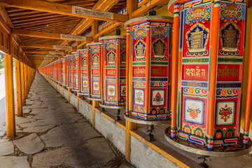 Row of praying wheels around Labrang Monastery in Xiahe town, Gansu province, China