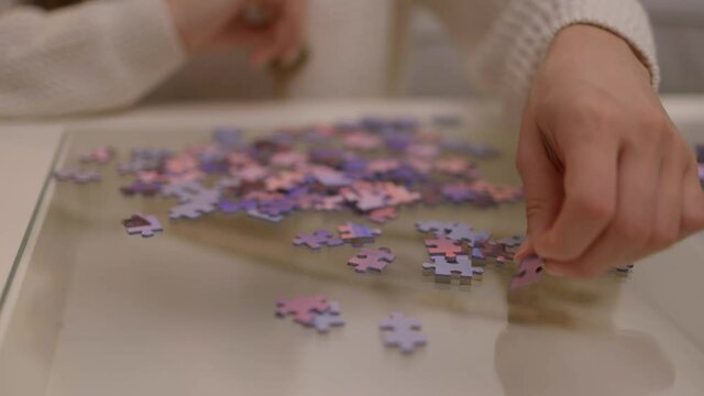 Young woman spends time with puzzles - videoclip