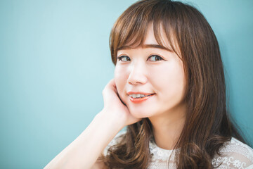 Naklejka premium カットモデル／水色の壁の前にいる女性 