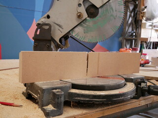 electric saw cutting for carpentry in workshop.