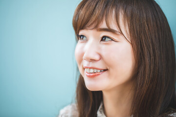 Naklejka premium 水色の壁の前にいる女性 