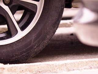 A dirty car wheel on the parking lot