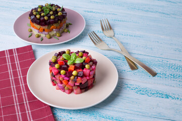 Salad of beets, carrots, potatoes, onions and green peas. Traditional Russian beetroot salad. Vegetarian vegetable salad.