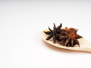 Dried star annise on a wooden spoon, shoot on a white isolated background