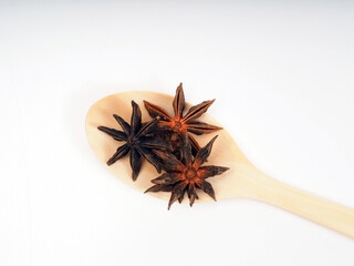 Dried star annise on a wooden spoon, shoot on a white isolated background