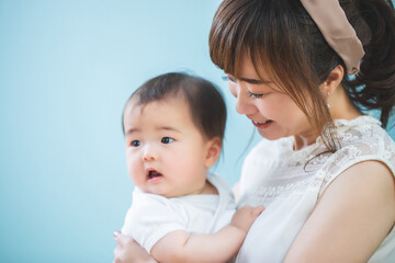 赤ちゃんを抱っこする笑顔の若いママ
