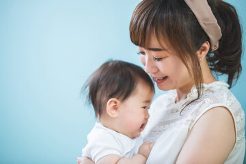 赤ちゃんを抱っこする笑顔の若いママ
