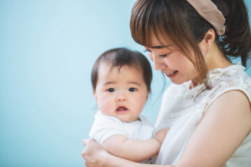 赤ちゃんを抱っこする笑顔の若いママ
