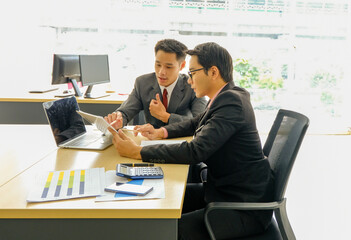 Two businessmen sitting at desk and discussing business matters. Business executives working in their office,finance, confident people, Successful leader.